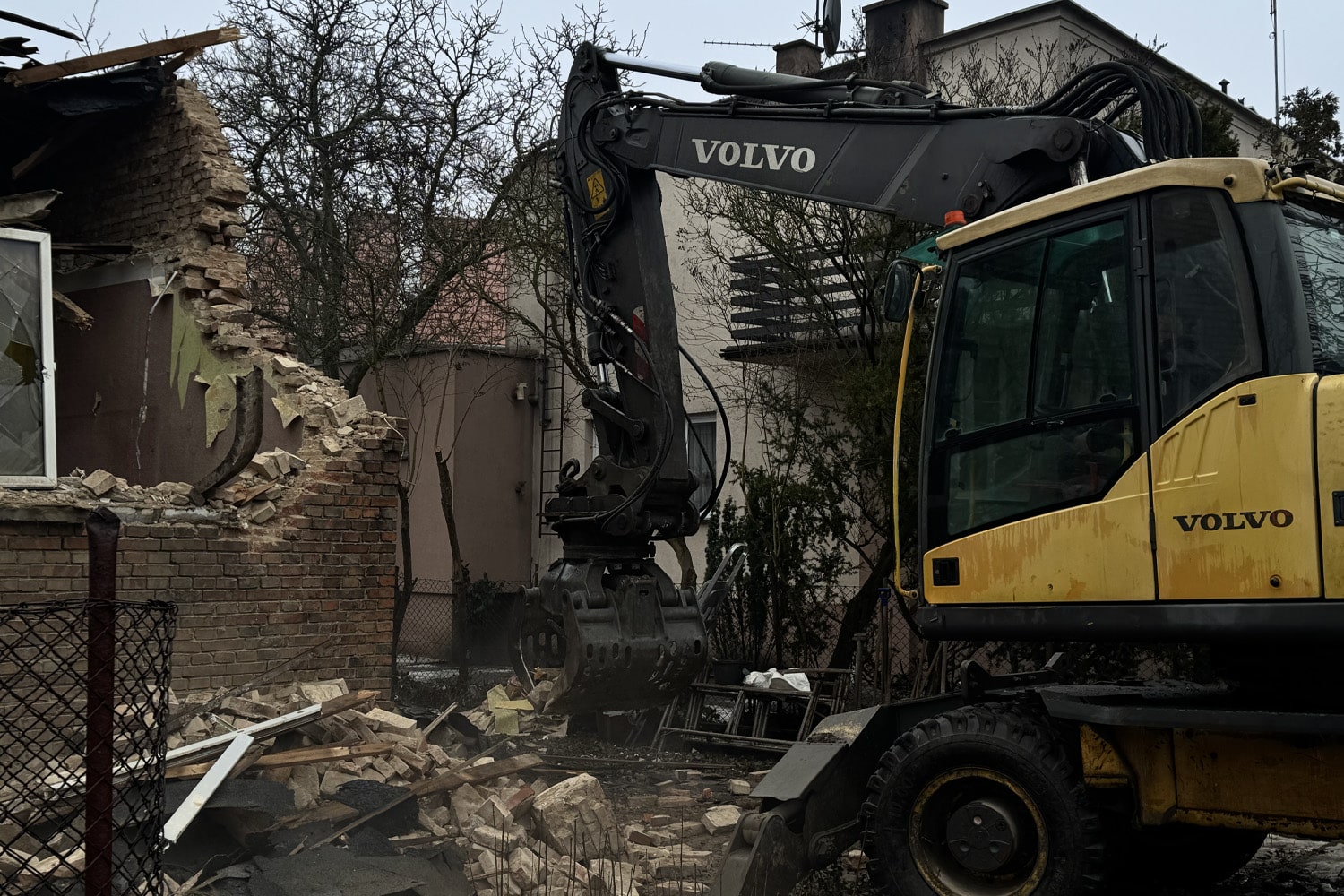 Koparka volvo podczas rozbiórki domu jednorodzinnego