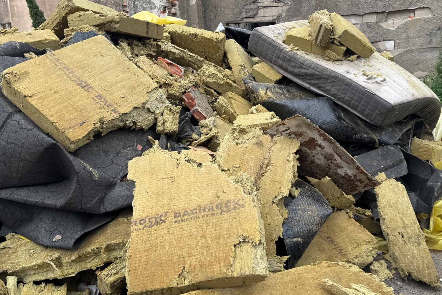 Fragmenty wełny mineralnej i innych materiałów izolacyjnych po rozbiórce